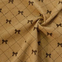 The Longan craft Bow Plaid Print Corduroy Fabric By The Yard is a heavyweight, soft, and durable corduroy material featuring a diamond grid checked pattern accented with small, dark brown bows at each intersection. This printed fabric gathers beautifully at the center, showcasing its cozy texture and gentle folds—ideal for creating comfortable and stylish clothing.