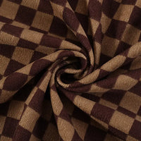 Close-up of Longan Craft's Checkered Corduroy Fabric By The Yard, a soft printed polyester corduroy with a vintage brown and tan checkered design, shown with ribbed texture gathered in a spiral pattern.