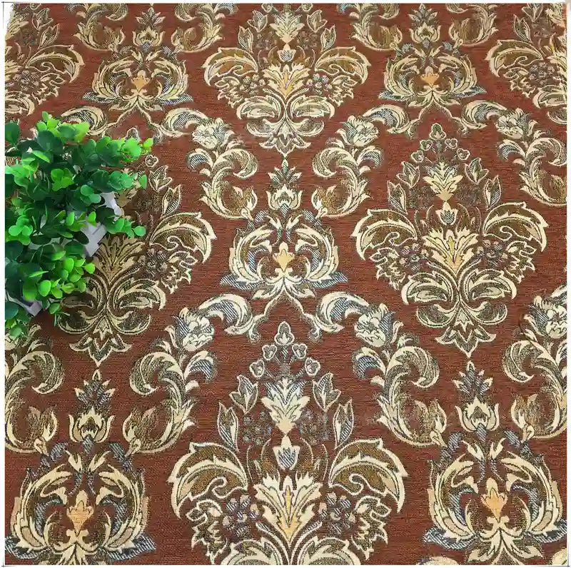 A green potted plant rests on Longan Craft's Chenille Damask Fabric By The Yard, a luxurious floral jacquard damask upholstery fabric ideal for elegant home décor.