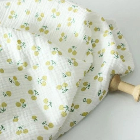 Longon Craft Cherry Print Double Gauze Fabric by the yard features soft crinkle double cotton gauze with small yellow cherries and green stems—ideal muslin fabric for sewing children’s clothing and more.