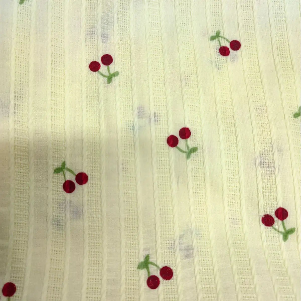 Cherry Printed Textured Dobby Fabric by Longan Craft features cozy cream cotton with vertical stripes and small red cherry prints with green stems—perfect for apparel. Available by the yard.