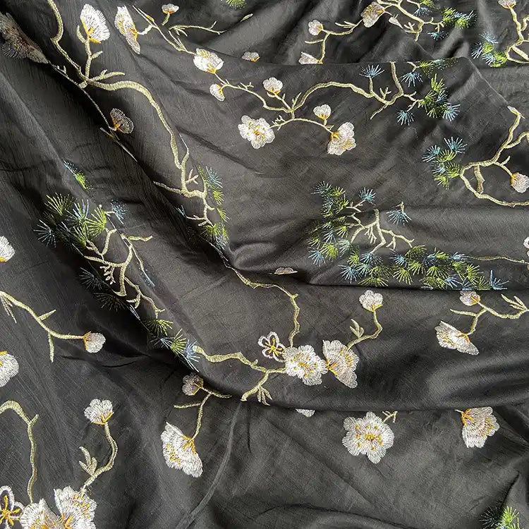 Longan Craft’s Chinoiserie Embroidered Silk Fabric By The Yard blends cotton and mulberry silk, featuring white and yellow floral embroidery with green leaves and blue accents—a premium fabric perfect for blouses.
