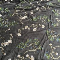 The Longan Craft Chinoiserie Embroidered Silk Fabric by the yard features a sheer black cotton-mulberry silk blend with delicate white flowers and green pine branch embroidery—perfect for elegant, nature-inspired blouses.