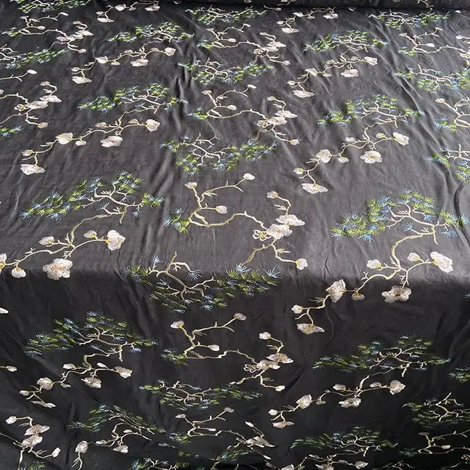 Longan Craft's Chinoiserie Embroidered Silk Fabric features a black base with light floral branches and green pine needles, crafted from premium cotton mulberry silk—ideal for blouses, available by the yard.