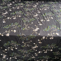 Longan Craft's Chinoiserie Embroidered Silk Fabric features a black base with light floral branches and green pine needles, crafted from premium cotton mulberry silk—ideal for blouses, available by the yard.