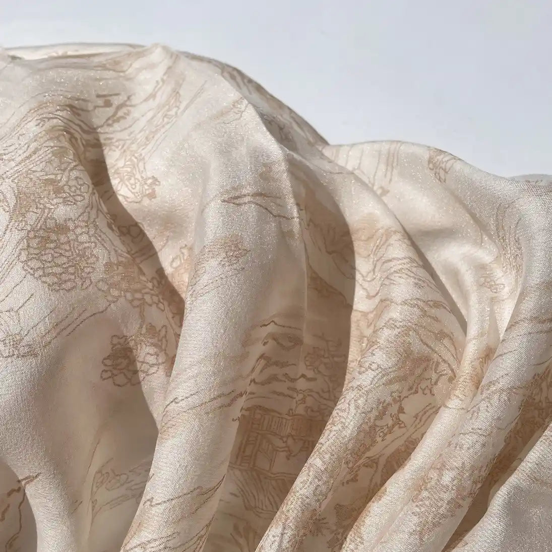 Longan Craft's Chinoiserie Printed Lyocell Fabric by the yard features a soft, light beige lyocell-polyester blend with subtle scenic patterns, ideal for dressmaking and beautifully illuminated by natural light.