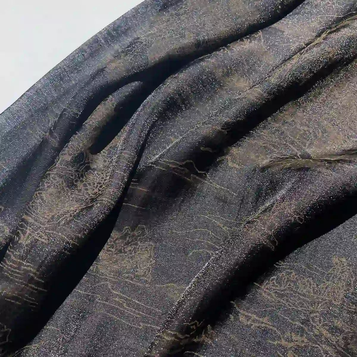 A close-up of Longan Craft's Chinoiserie Printed Lyocell Fabric by the yard, a soft polyester lyocell ideal for dressmaking, featuring colorful patterns and a subtle texture draped in natural light.