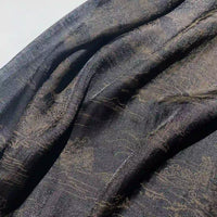 A close-up of Longan Craft's Chinoiserie Printed Lyocell Fabric by the yard, a soft polyester lyocell ideal for dressmaking, featuring colorful patterns and a subtle texture draped in natural light.