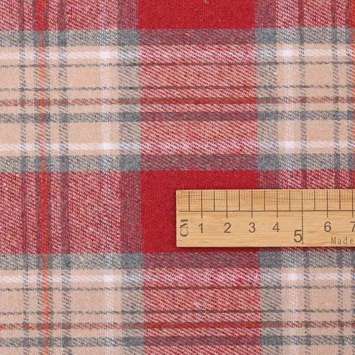 A Longan Craft Christmas Plaid Sueded Flannel Fabric by the yard is shown beneath a wooden ruler marked in centimeters for scale—the checked holiday design and soft brushed textile make it ideal inspiration for cozy seasonal sewing projects, such as classic dresses and crafts.