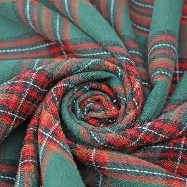 Close-up of green, red, white, and black plaid fabric from Longan Craft’s Christmas Plaid Sueded Flannel Fabric By The Yard twisted into a spiral, highlighting its soft, sueded texture and intricate woven design—ideal for holiday sewing projects with this checked holiday flannel textile perfect for classic dresses and festive décor.