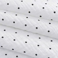 Close-up of Longan Craft's Classic Small Polka Dot Gauze Fabric by the yard—100% cotton double gauze with a textured white surface and evenly spaced black polka dots, ideal for baby clothing and pajamas.