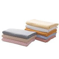 A stack of Classic Small Polka Dot Gauze Fabric by Longan Craft, made from 100% cotton double gauze, in pastel colors and polka dot patterns, arranged in two piles on a white background.