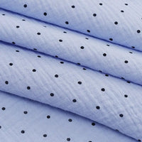The Classic Small Polka Dot Gauze Fabric by Longan Craft is 100% cotton double gauze with small black polka dots on light blue. Shown folded, it's ideal for baby clothing, pajamas, or delicate projects. Sold by the yard.