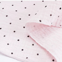 Classic Small Polka Dot Gauze Fabric by Longan Craft—100% cotton double gauze with soft texture and small black polka dots. Ideal for baby clothing and pajamas, this flexible fabric is sold by the yard.