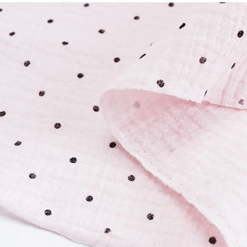 Classic Small Polka Dot Gauze Fabric by Longan Craft—100% cotton double gauze with soft texture and small black polka dots. Ideal for baby clothing and pajamas, this flexible fabric is sold by the yard.