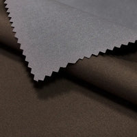 A detailed view of Longan Craft’s Coated Waterproof Peachskin Fabric By The Yard—two overlapping microfiber polyester swatches, dark brown and gray, with the gray peachskin showing a zigzag-cut edge ideal for cozy jacket making.