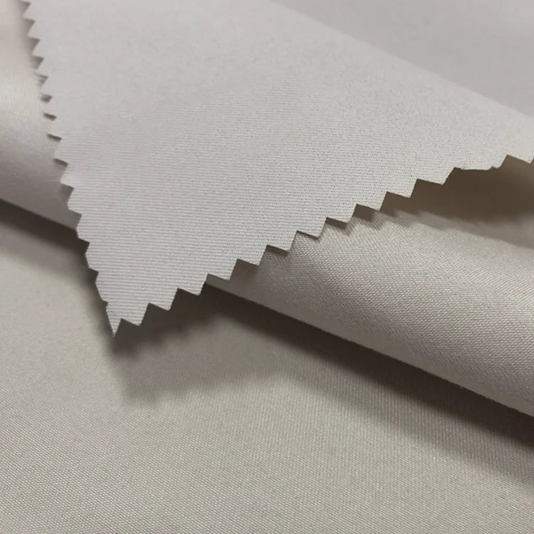 Close-up of Longan Craft's Coated Waterproof Peachskin Fabric by the yard, a microfiber polyester material with a soft, smooth texture and zigzag-cut edge, showcasing its clean finish and waterproof quality—perfect for jacket making.