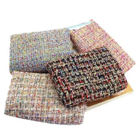 Four folded pieces of Longan Craft’s Colorful Boucle Tweed Fabric By The Yard, a luxurious, thick, and textured woven tweed fabric ideal for blazers and clothing, are arranged on a flat surface, showcasing various vibrant colors and patterns.