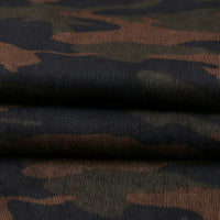 A close-up of Longan Craft's Colorful Camouflage Corduroy Fabric by the yard displays its quality weave and distinct dark green and brown camouflage pattern, ideal for clothing.