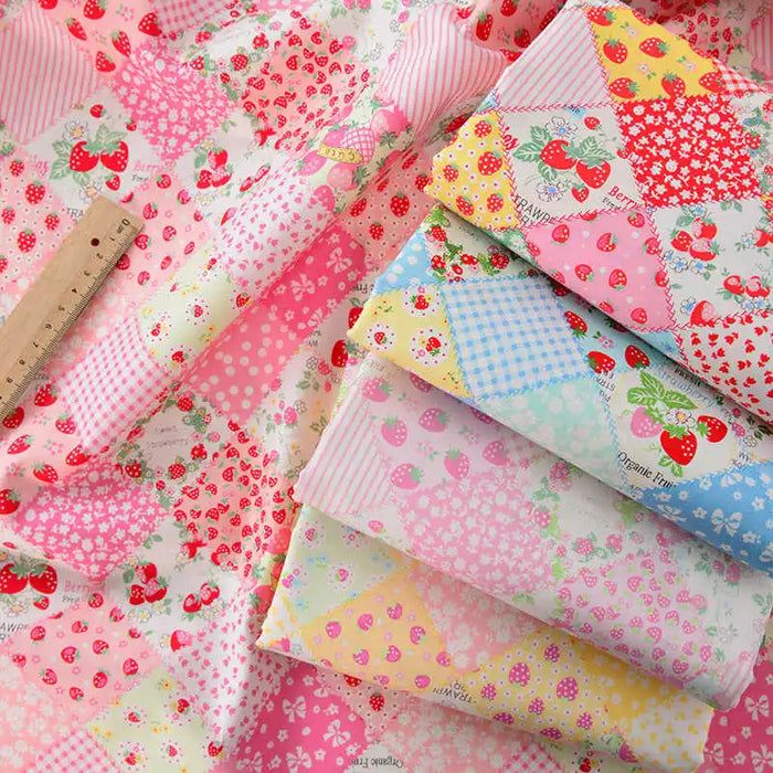 Several pastel pink, yellow, blue, and green Colorful Checked Floral Poplin Fabrics by Longan Craft, featuring patchwork plaid, strawberries, flowers, and polka dots, are displayed with a wooden ruler. Ideal for vibrant garments and crafts.