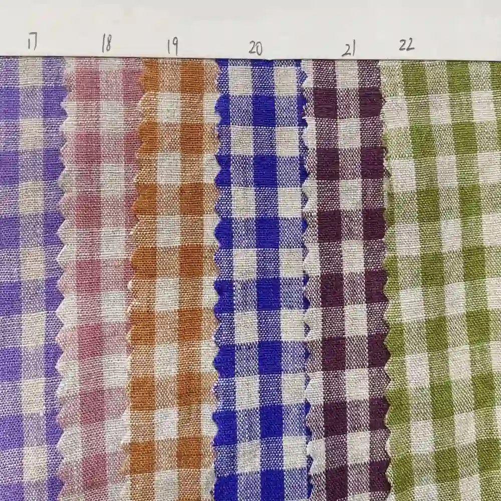 Six swatches of the Longan Craft Colorful Checkered Linen Fabric By The Yard, each in a different color and numbered 17 through 22 from left to right, are displayed in a row on a white background, with their zigzag-cut edges clearly visible. This 100% washed linen gingham fabric is ideal for dressmaking and other sewing projects.
