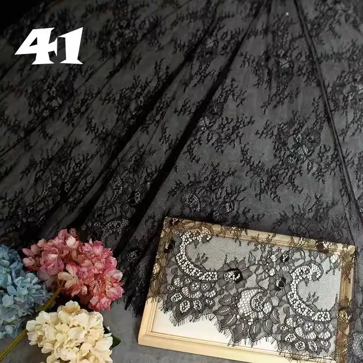 Longan Craft's Colorful Floral Embroidered Lace Fabric by the yard, featuring a vintage scalloped botanical pattern, is displayed beside pink, blue, and cream artificial flowers. Number 41 appears at the top left. Ideal for weddings or evening wear.