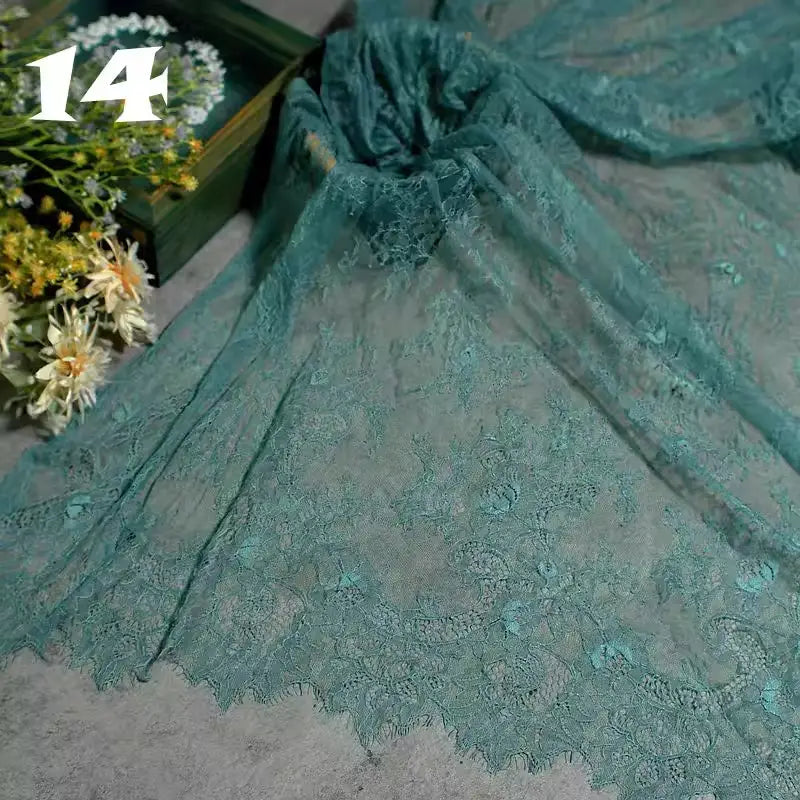 Colorful Floral Embroidered Lace Fabric by Longan Craft, featuring a vintage scalloped botanical pattern, is spread on a grey surface with fresh flowers. The number 14 is visible in the top left corner.