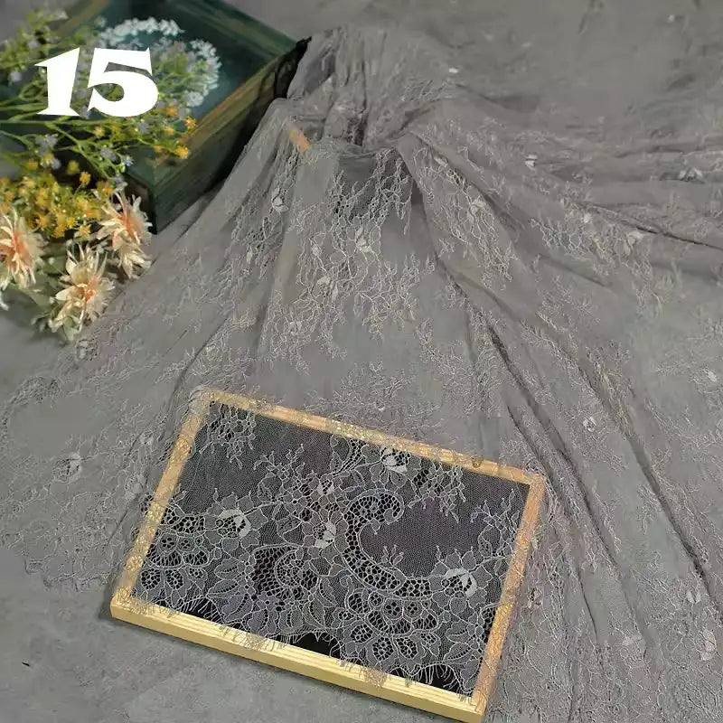 Longan Craft’s Colorful Floral Embroidered Lace Fabric with vintage scalloped edges and botanical patterns drapes over a wooden frame beside a bouquet of flowers, with the number 15 in white in the upper left corner.