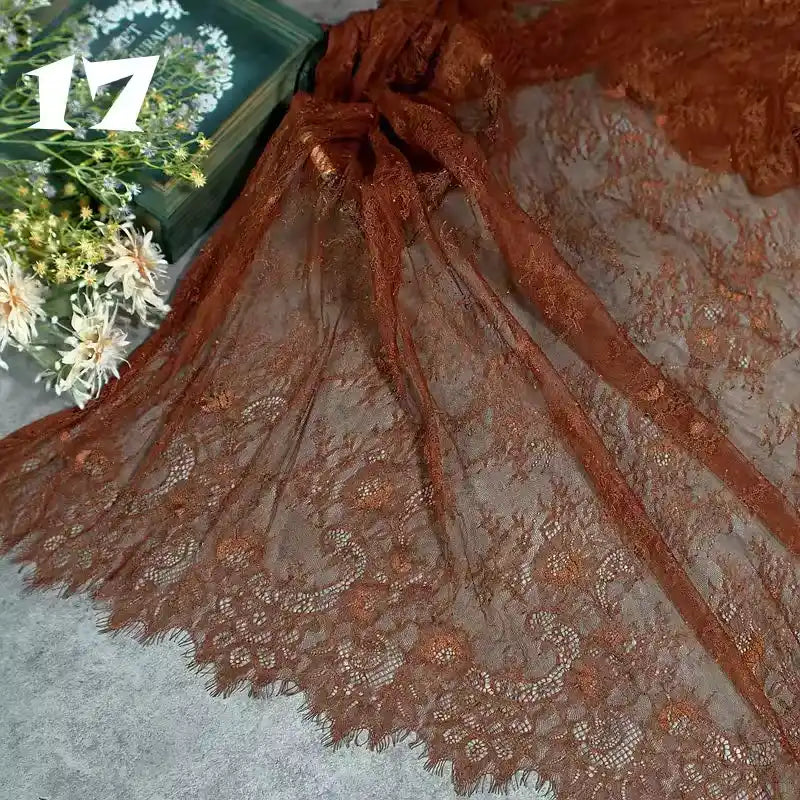 Longan Craft’s Colorful Floral Embroidered Lace Fabric By The Yard, featuring a vintage scalloped botanical pattern, is displayed on a gray surface with white flowers and a green box in the background; “17” appears at the top left.