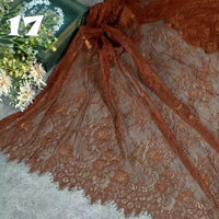 Longan Craft’s Colorful Floral Embroidered Lace Fabric By The Yard, featuring a vintage scalloped botanical pattern, is displayed on a gray surface with white flowers and a green box in the background; “17” appears at the top left.