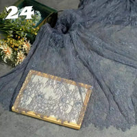 A piece of Longan Craft Colorful Floral Embroidered Lace Fabric By The Yard with a vintage botanical pattern is draped over a surface, partially covering flowers and a book. The number 24 appears in the top left corner.