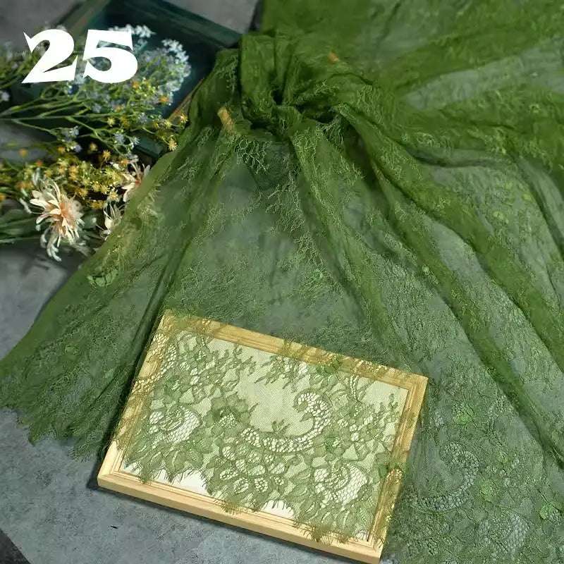 The Colorful Floral Embroidered Lace Fabric by Longan Craft features a vintage scalloped botanical pattern, ideal for wedding gowns or elegant projects. Displayed with flowers beside it, code 25 marks this delicate material.