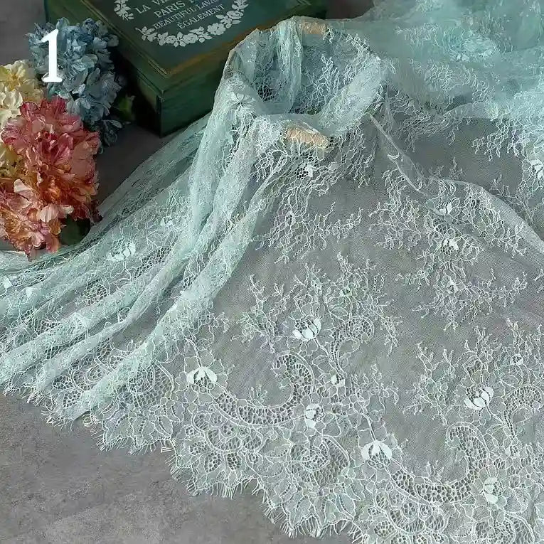 Colorful Floral Embroidered Lace Fabric By The Yard from Longan Craft, featuring vintage scalloped edges and botanical patterns, is displayed with pastel flowers, a green book, and a number 1 in the upper left corner—ideal for wedding gowns or evening wear.