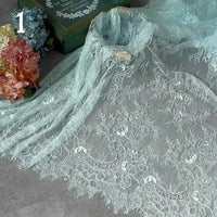 Colorful Floral Embroidered Lace Fabric By The Yard from Longan Craft, featuring vintage scalloped edges and botanical patterns, is displayed with pastel flowers, a green book, and a number 1 in the upper left corner—ideal for wedding gowns or evening wear.