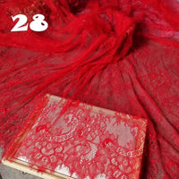 A bolt of Longan Craft's Colorful Floral Embroidered Lace Fabric, featuring a vintage scalloped botanical pattern, is displayed—ideal for delicate wedding gowns. A folded section sits on a book with the number 28 above.