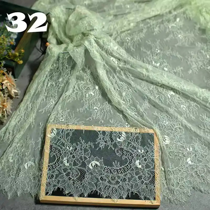 Longan Craft Colorful Floral Embroidered Lace Fabric by the Yard, featuring vintage scalloped edges and a botanical pattern, is draped and displayed with a framed sample. The number 32 appears in the top left corner.