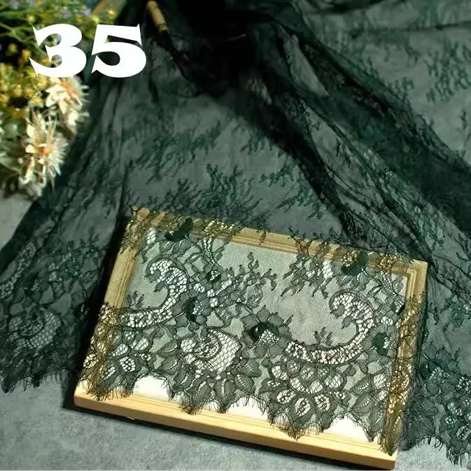 A piece of Colorful Floral Embroidered Lace Fabric by Longan Craft is displayed beside a wooden frame holding more of this vintage scalloped botanical lace, ideal for wedding gowns or evening wear. The number 35 appears in white at the top left.