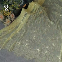 Longan Craft’s Colorful Floral Embroidered Lace Fabric By The Yard is spread on a surface with flowers behind it; the delicate vintage scalloped botanical lace features a bold number 2 in the top left corner.