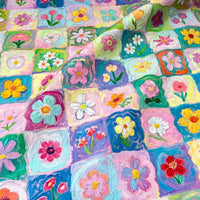 Colorful Floral Print Canvas Fabric By The Yard featuring a grid of squares, each painted with a different flower in a thick, textured brushstroke style.