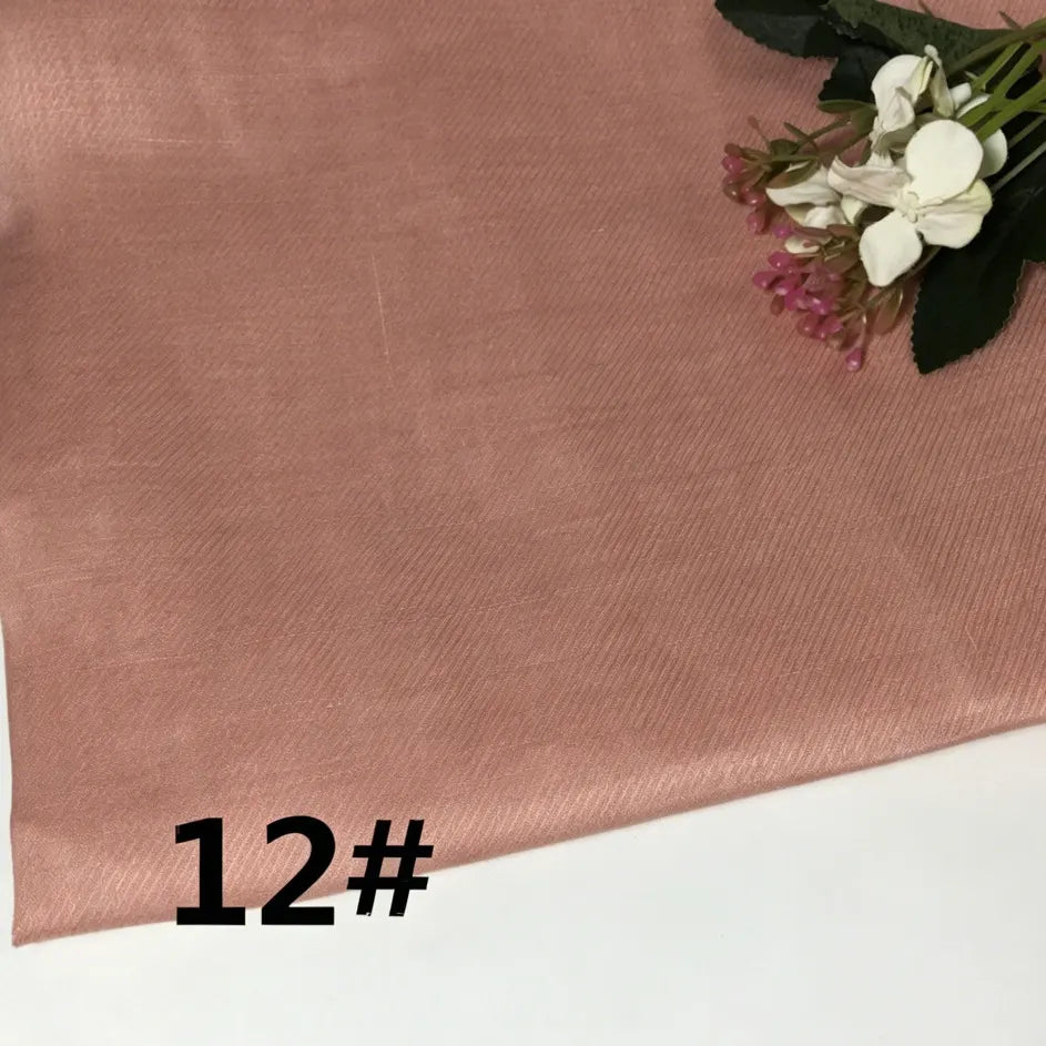 A piece of Longan Craft Colorful Lightweight Ramie Fabric By The Yard in rose gold, labeled “12#” in black text, features white and pink artificial flowers and green leaves arranged in the top right corner.