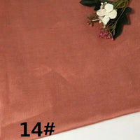 A piece of Longan Craft Colorful Lightweight Ramie Fabric By The Yard in a dusty rose hue is laid flat, adorned with a small white flower arrangement at the top right. The number 14# appears in bold black print at the bottom left corner.