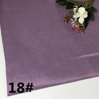 A swatch of light purple, colorful lightweight ramie fabric by Longan Craft, labeled “18#” in bold black text, displays its soft texture and subtle sheen. White and pink artificial flowers are arranged on the upper right corner, highlighting the pure ramie material ideal for garment making.