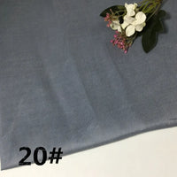 A piece of Colorful Lightweight Ramie Fabric By The Yard from Longan Craft in a light gray solid color, featuring a small bouquet of white and pink artificial flowers in the top right corner. The number 20# is printed in black in the bottom left corner.