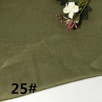 Olive green Colorful Lightweight Ramie Fabric By The Yard from Longan Craft is laid flat, with a small artificial floral arrangement in the top right corner. The number 25# is printed in black in the bottom left corner.