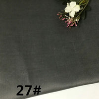 A sample of Longan Craft’s Colorful Lightweight Ramie Fabric By The Yard, featuring a dark gray textured solid color, is shown with delicate white and pink flowers arranged in the corner. The product number 27# appears in bold black text at the bottom left.