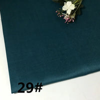 A piece of teal blue “Colorful Lightweight Ramie Fabric By The Yard” from Longan Craft is displayed flat, with a small bouquet of white and pink artificial flowers in the corner. The number 29# is printed in black on the lower left side.