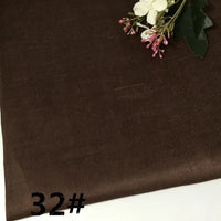 A sample of Longan Craft’s Colorful Lightweight Ramie Fabric By The Yard, in a brown shade with a subtle diagonal texture, is displayed alongside a small artificial flower arrangement in the corner. The number 32# appears in bold black text in the lower left corner.