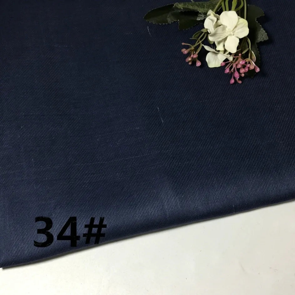 A piece of dark blue Colorful Lightweight Ramie Fabric by the yard from Longan Craft is laid flat, with small artificial white and pink flowers arranged on top. The number 34# appears in black in the bottom left corner.