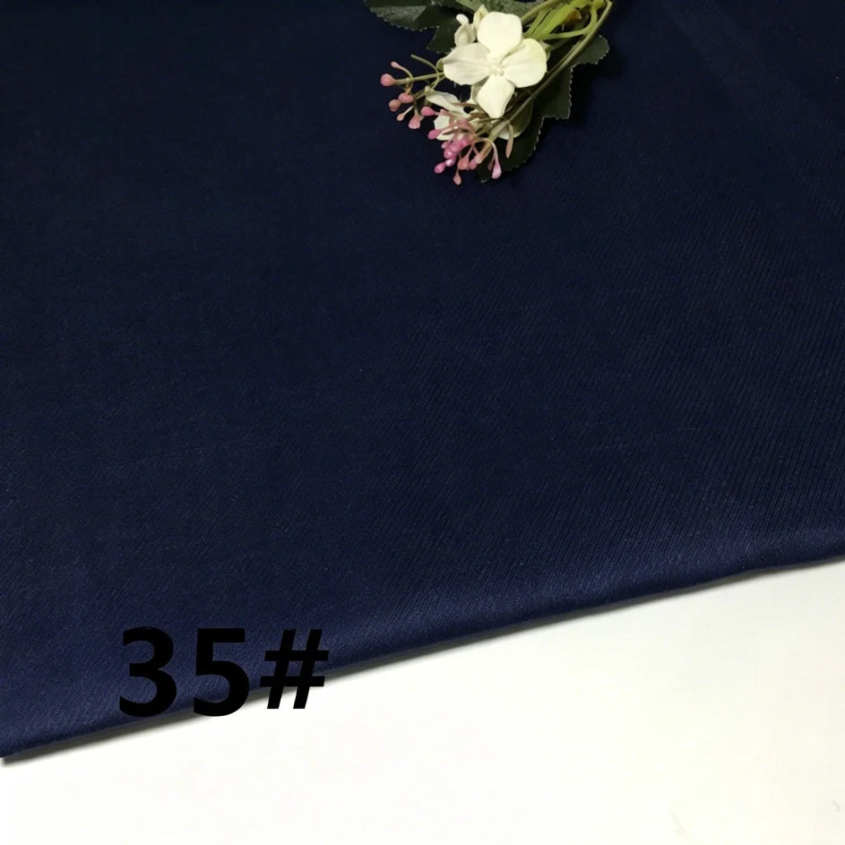 A piece of Colorful Lightweight Ramie Fabric By The Yard from Longan Craft in a dark blue shade is laid out flat with a small artificial flower arrangement placed on top. The number 35# is printed in black on the lower left corner.
