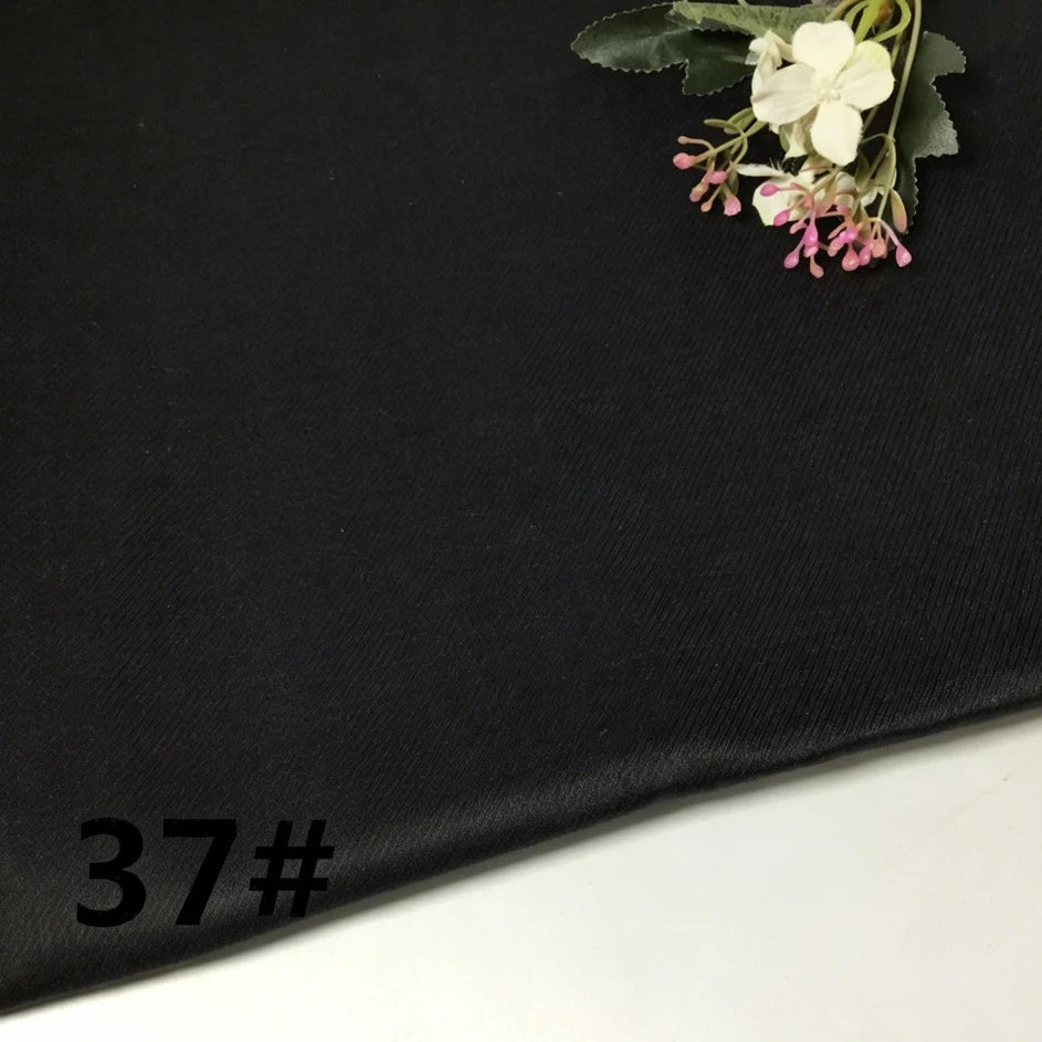 A piece of black, lightweight ramie fabric from Longan Craft’s “Colorful Lightweight Ramie Fabric By The Yard” collection features a small floral arrangement in the top right corner, with the number 37# printed in black at the lower left.
